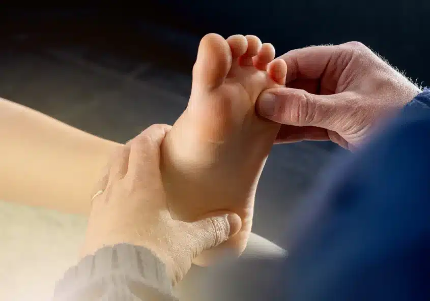 Un podólogo examina con delicadeza el pie de un niño, proporcionándole una atención especializada para los trastornos del pie en Metro Healthcare Partners.